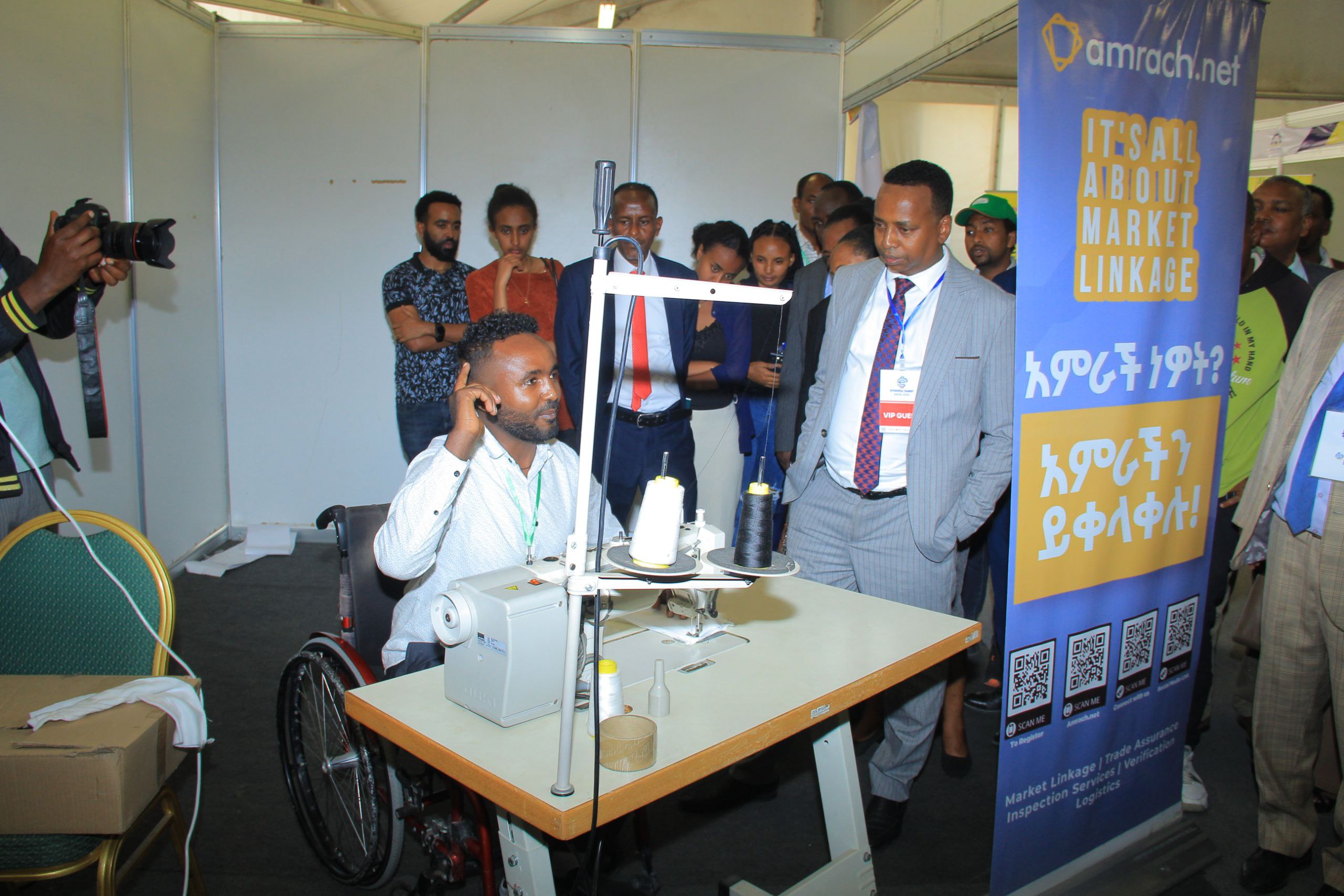 Demonstrating adaptive sewing machine to officials